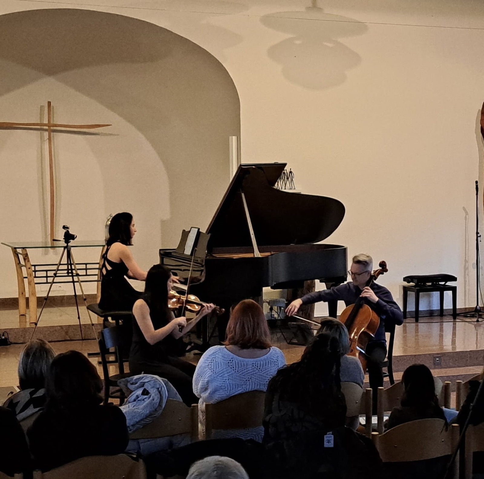 Streichtrio im Konzert in einer Kirche, im Hintergrund ein Kronleuchter