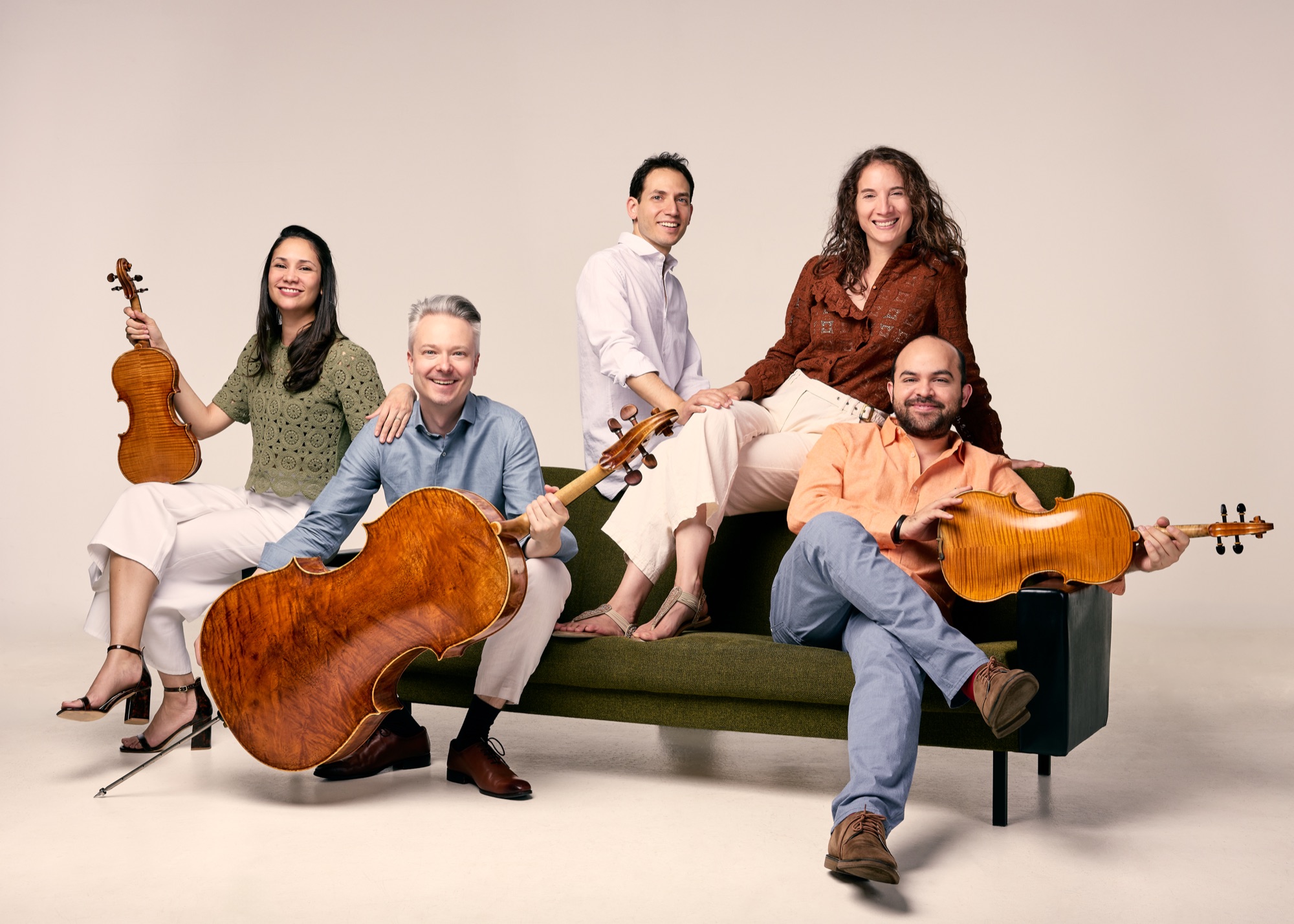 Die fünf Mitglieder des Taru Ensembles mit ihren Instrumenten auf einem Sofa